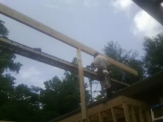 Carpenter setting a ridge beam over a new addition frame in Smiths Creek