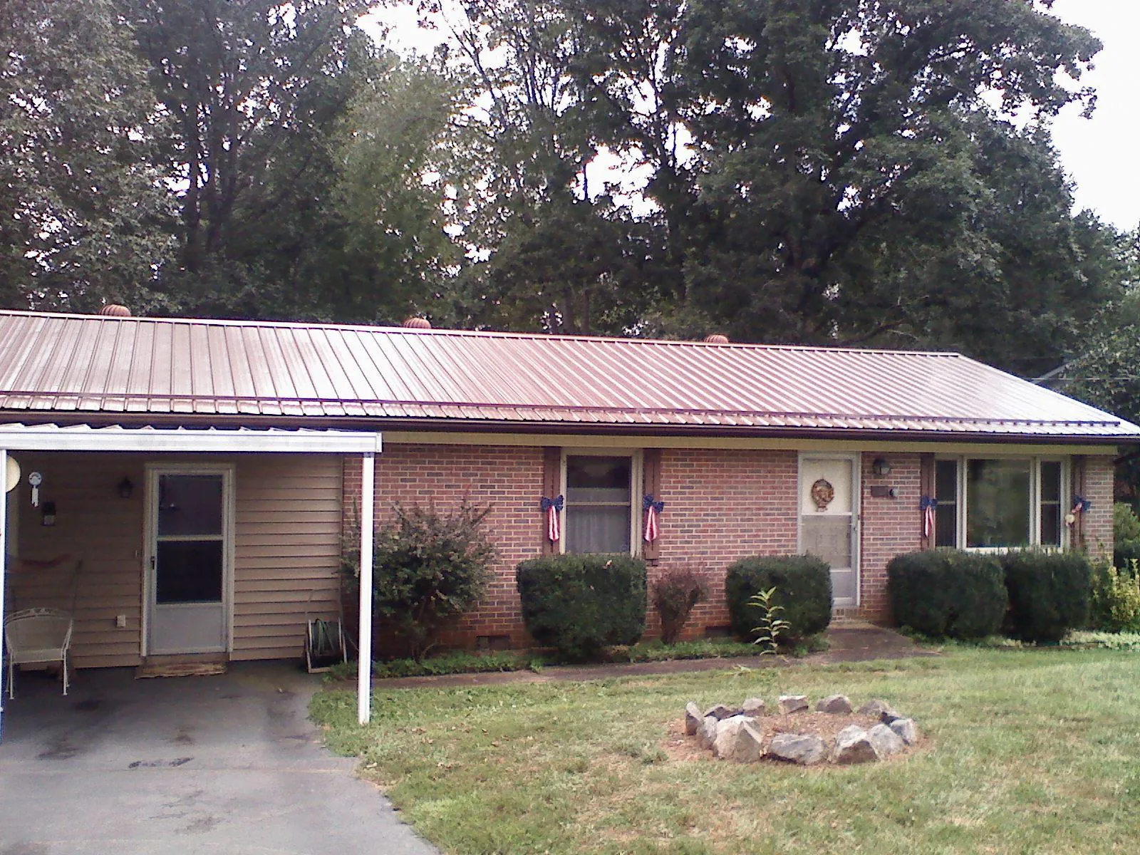 Bronze metal roof and carport on a brick ranch home — Roof Repair work by our crew in Smiths Creek