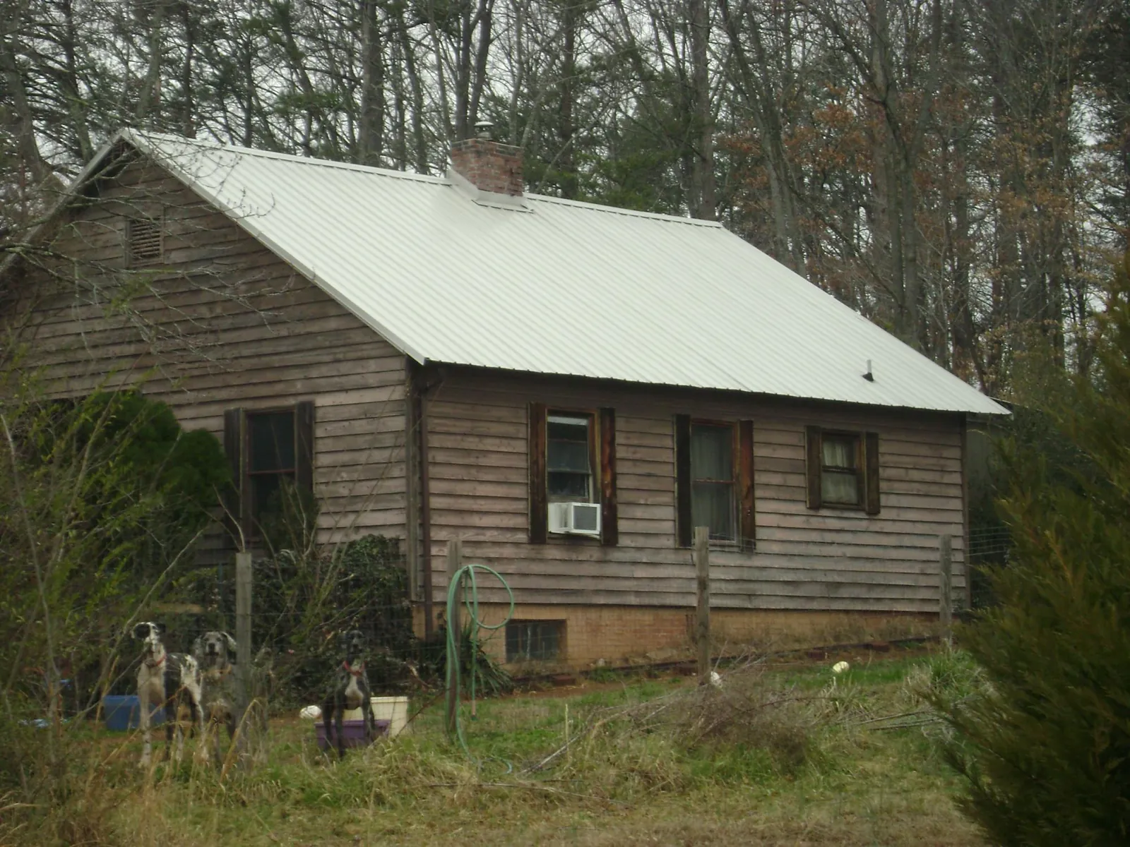 White metal roof on an old wood sided farmhouse, from a Metal Roof Installation job in Smiths Creek